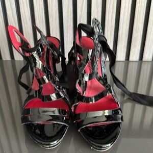 Lanvin black patent strappy lace up sandal. 5 inch metallic heel